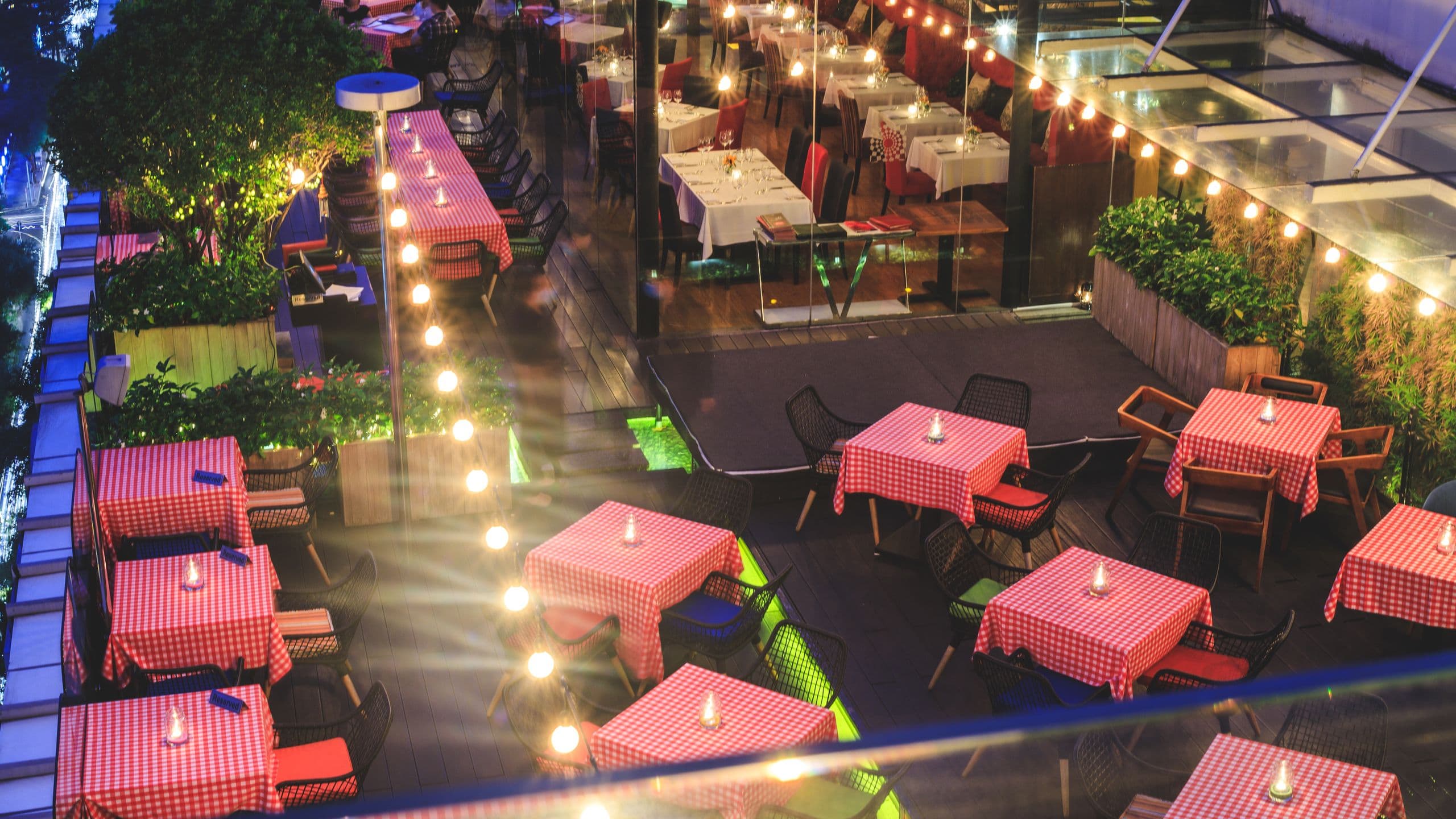 Rooftop tables at night above city lights