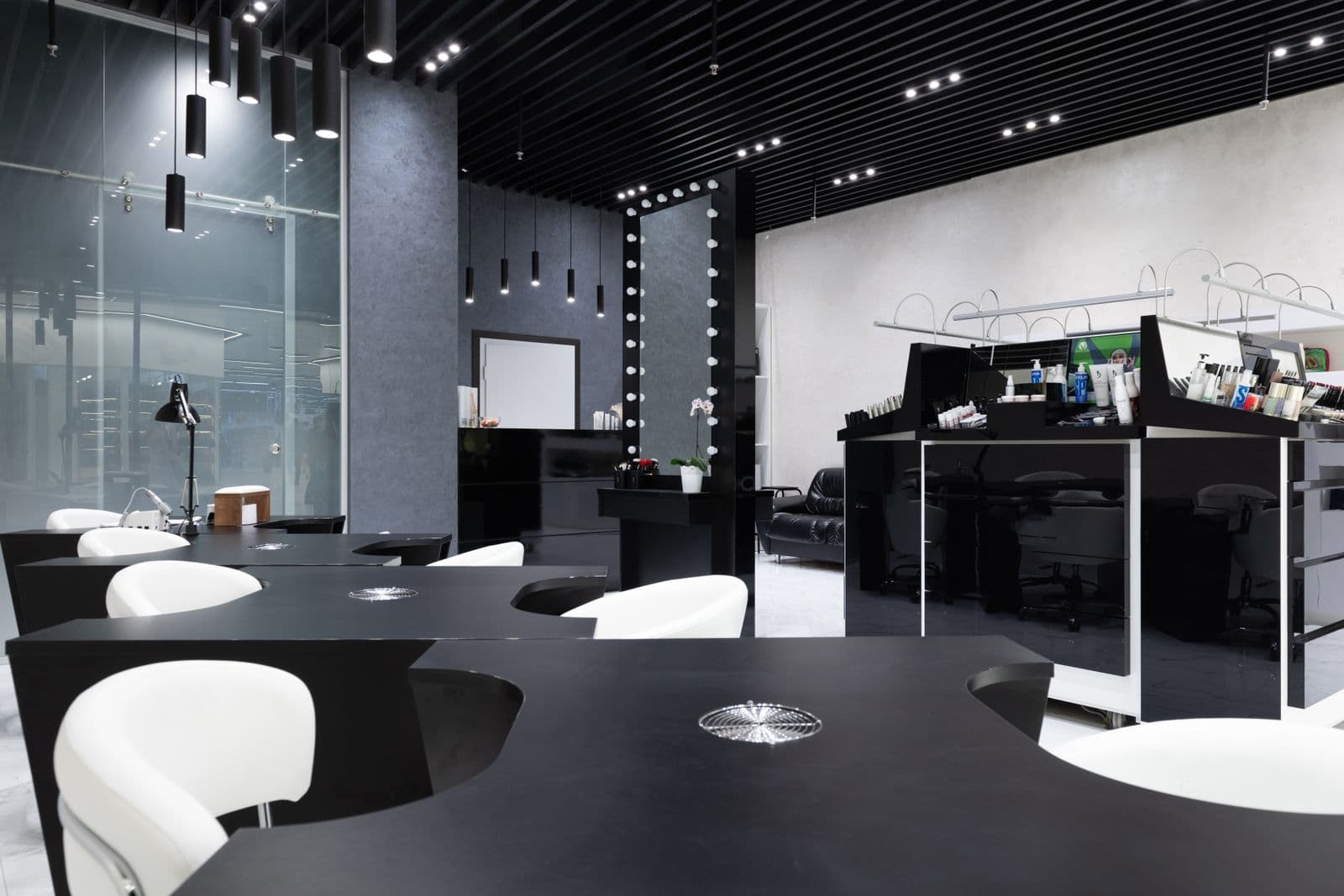 Nail stations in a black and white salon, every chair empty