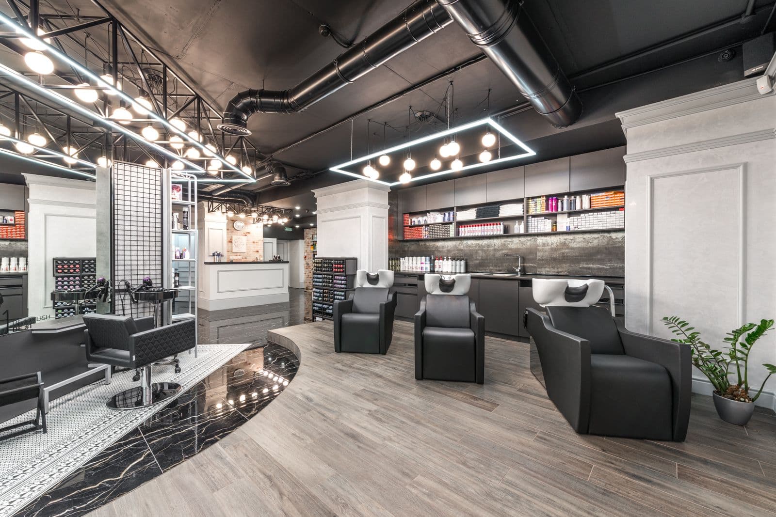 Salon floor, chairs empty, mirrors lit